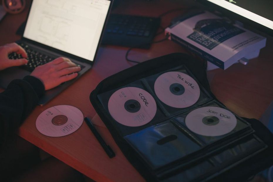 CD-R s ručně psaným názvem kapely ležící na pracovním stole