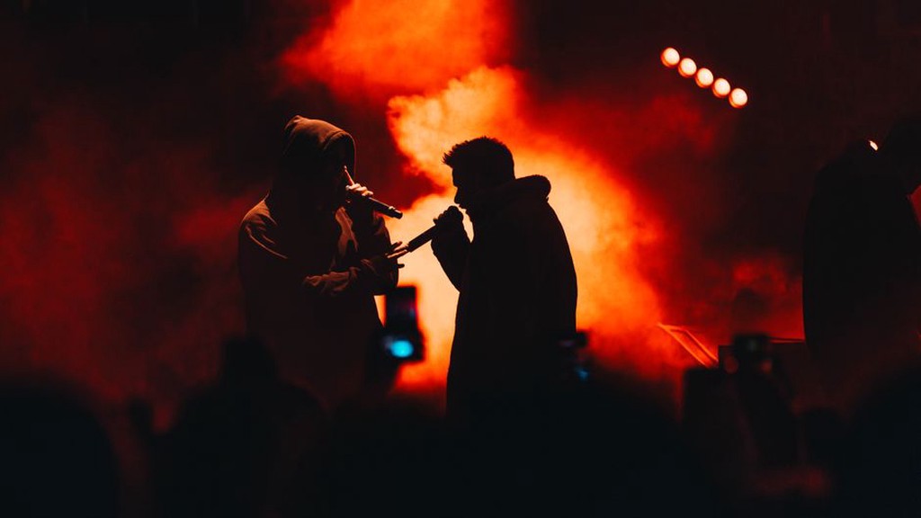 koncert industriální kapely v hustém kouři a červeném osvětlení