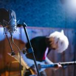 Mikrofon, poznámky a temná studiová atmosféra