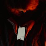 Osamělá postava osvětlená obrazovkou telefonu