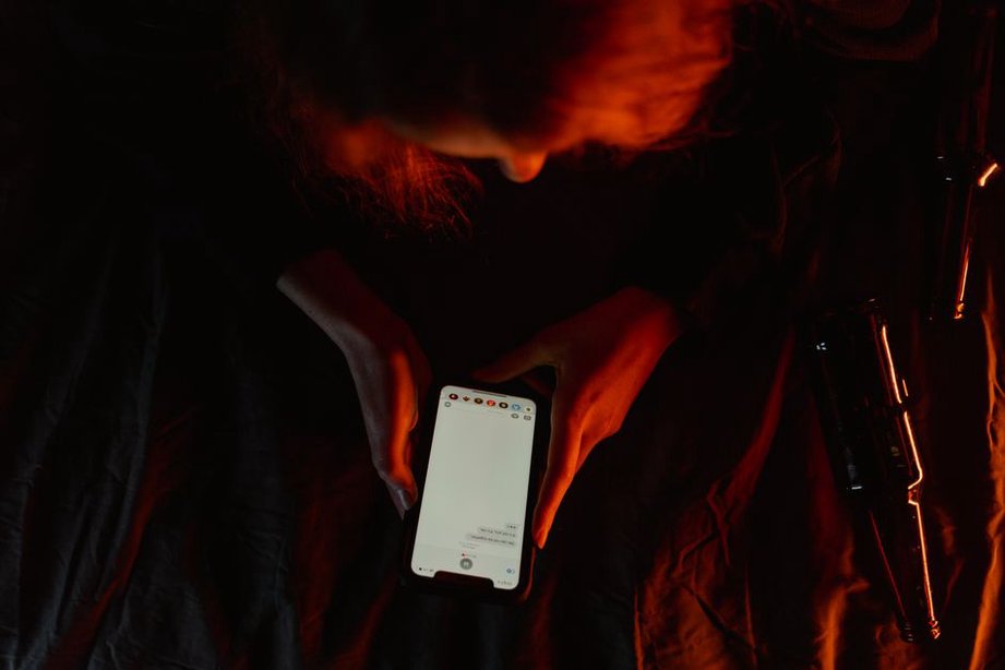 Osamělá postava osvětlená obrazovkou telefonu