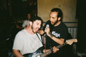 Publikum v potemnělém klubu sleduje koncert