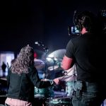 Projekce za kapelou ponechává hudebníky ve tmě