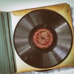 Vinylový obal a booklet položené vedle desky